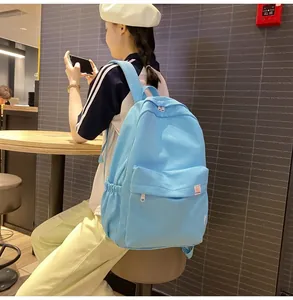 Sky blue minimalist backpack with drawstring side pockets and fine textured nylon fabric