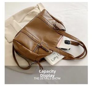 Capacity display of brown large tote bag with interior books and smartphone