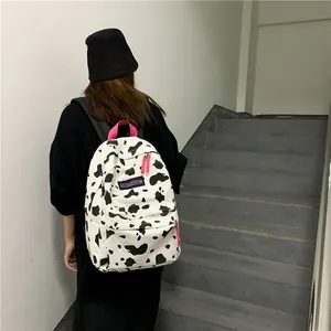 Sac à dos en toile pour étudiante avec motif vache noir et blanc et détails roses