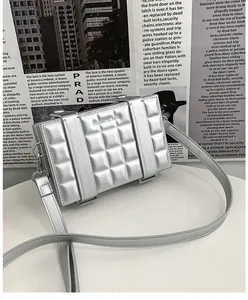 Macro detail of silver rectangular box bag featuring quilted texture and metallic finish