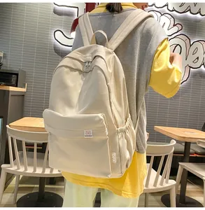 Detail of cream canvas backpack featuring side pocket and DIFA'S BEAR brand logo patch