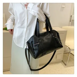 Detail of black textured leather tote with silver zippers and adjustable shoulder strap