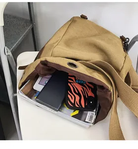 Vue détaillée de l'intérieur du sac en toile kaki avec magazines et objets du quotidien