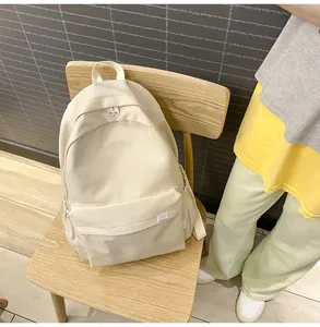 Detail of cream canvas backpack featuring Difa's Bear logo and multi-pocket storage