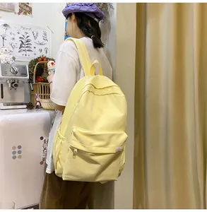 Detailed view of the yellow canvas backpack straps and fabric texture on a model