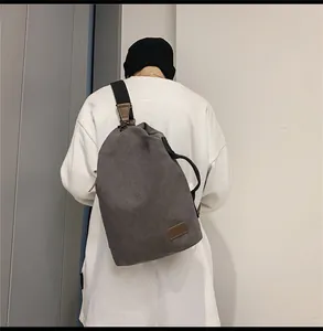 Dettaglio di una grande borsa a tracolla in tela grigio scuro con inserti in pelle marrone