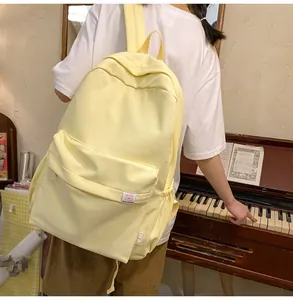 Detail of soft cream canvas backpack with wide shoulder straps on a lifestyle model