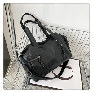 Close-up of black rivet handbag with zipper tassels and adjustable strap details