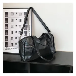 Detail view of the black Boston handbag showing high-quality leather texture and side zipper