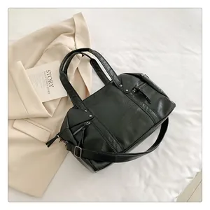 Detail view of high-quality black leather tote bag with stylish zipper pockets and dual straps