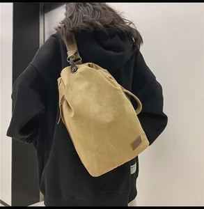 Dettaglio della borsa a tracolla in tela kaki con coulisse e fibbia in metallo sulla tracolla