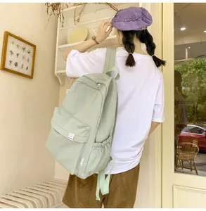 Detail shot of light green campus backpack featuring front pocket and side elastic pocket