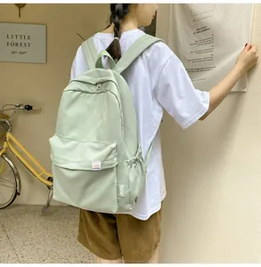 Detail of light green minimalist canvas backpack with large main pocket and side pocket