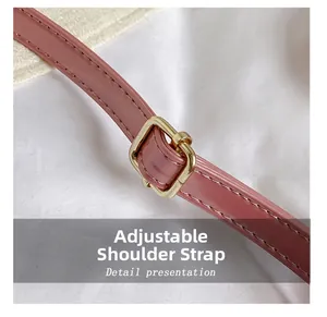 Detailed macro view of the pink adjustable leather shoulder strap with gold metal buckle