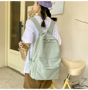 Close-up of light green corduroy backpack with small cartoon patch and side pocket