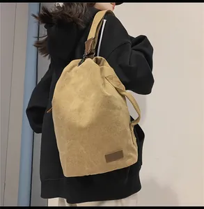 Vista dettagliata della borsa a secchiello in tela kaki indossata da un modello con capienza