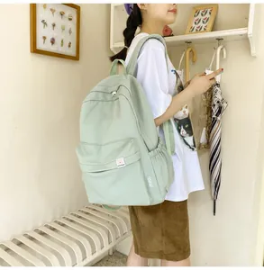 Detail of mint green school backpack featuring a side view of adjustable straps and side pockets