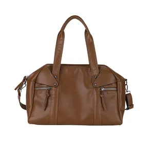 Brown leather tote bag with double handles and metal stud accents on white background
