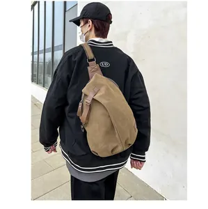 Outdoor model shot of a dark brown canvas crossbody chest bag with adjustable strap
