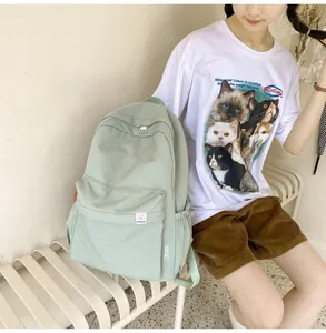 Detail of light green waffle fabric backpack featuring teddy bear patch and front pocket