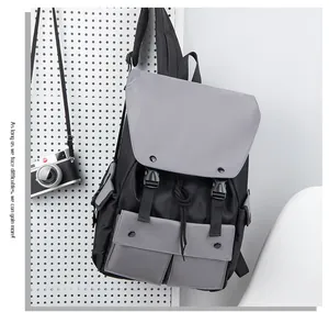 Close-up of black and grey nylon backpack featuring dual buckle closure on a pegboard