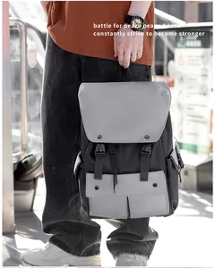 Outdoor shot of a classic black and gray nylon backpack featuring dual buckle front pockets