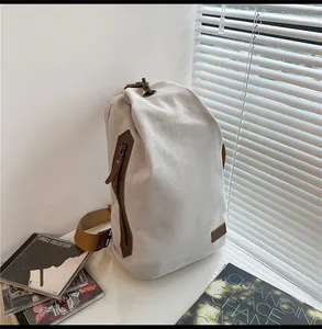 Dettaglio della borsa a tracolla vintage in tela con zip in pelle e tasca laterale
