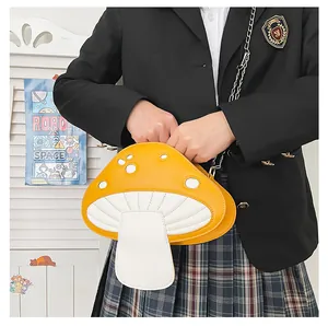 Détail du sac bandoulière champignon jaune à pois blancs et chaîne argentée sur modèle