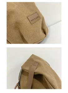 Detailed close-up of brown canvas shoulder bag featuring brand label and zipper texture