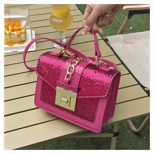 Detail of rose red sequin crossbody bag with gold hardware on a camping table