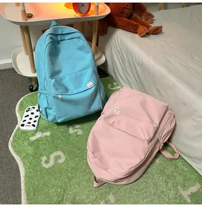 Detail of blue and pink pastel backpacks with zipper pockets and side pockets in a bedroom