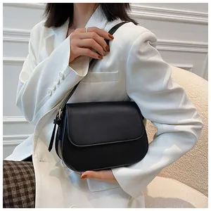 Minimalist black matte leather saddle bag shown on model for professional daily commute