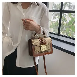 Detail of a brown patent leather and gold sequin crossbody bag with a metallic twist lock
