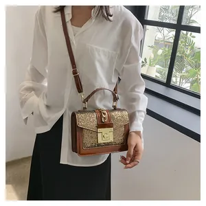 Deep brown crossbody bag with gold sequin flap and metal lock shown on a model