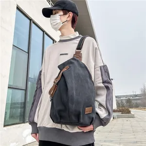 Japanese style men's canvas chest bag in black with brown leather accents shown on a model