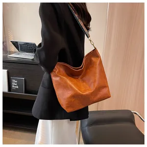 Detail view of brown PU leather tote with ethnic style woven wide shoulder strap