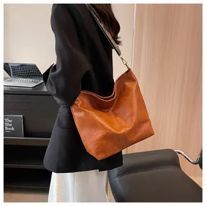 Brown faux leather tote bag close-up showing texture and colorful ethnic wide shoulder strap