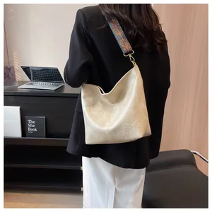 Chic beige textured faux leather tote with colorful ethnic wide strap in office setting