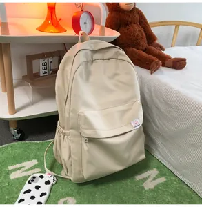 Detail view of large capacity beige nylon backpack showing mesh texture and side pockets