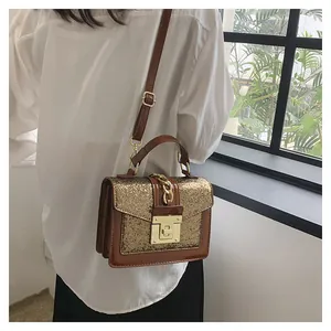 Detail view of a mini square crossbody bag featuring gold sequins and brown leather