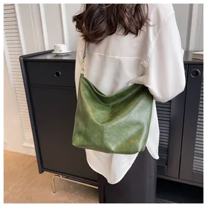Detail of dark green leather shoulder bag with vintage texture and stylish woven strap