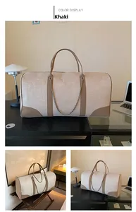 Detail view of khaki canvas travel tote with leather trim and metallic chain accent