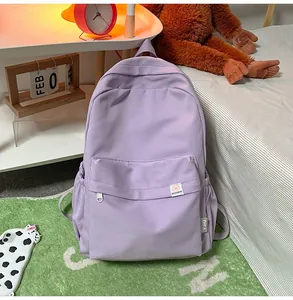 Detail of light purple corduroy backpack with multi-pocket design and cute bear logo