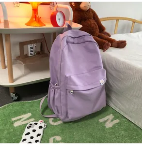 Detail of purple student backpack showing fine grid texture and front zipper pocket