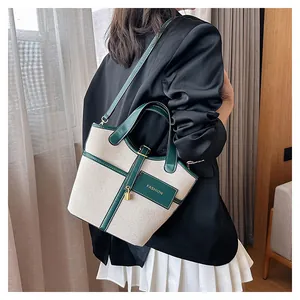Canvas and green leather bucket bag styled with a black blazer and white pleated skirt
