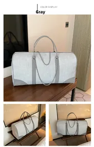 Detail view of large grey canvas tote bag with leather handles and silver chain accents