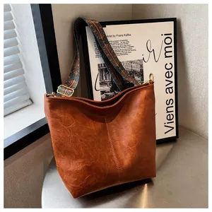 Close-up of caramel tote bag featuring a textured finish and vintage ethnic pattern strap