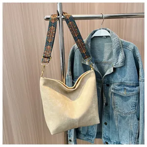 Detail of cream leather tote bag featuring a colorful geometric patterned wide strap