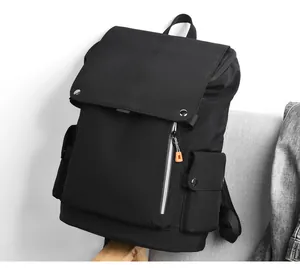Detail view of black nylon backpack featuring matte finish and orange zipper accent