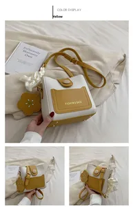 Détails du sac seau jaune et beige avec breloque fleur et nœud en ruban élégant